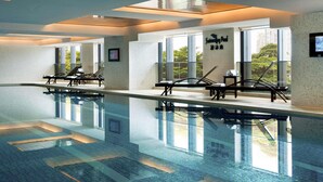 Una piscina con sillas de descanso y vistas despejadas al exterior.