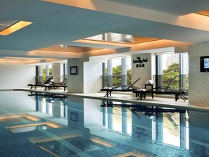 A swimming pool with lounge chairs and a clear view of the outdoors. - Pullman Foshan Shunde (Foshan)