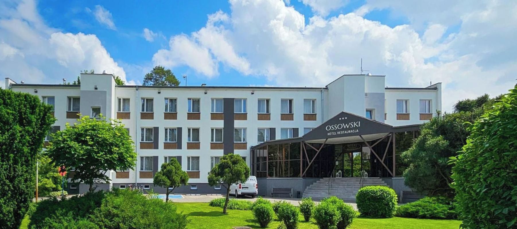 Ein Hotel mit moderner Fassade, überdachter Eingangspartei und gepflegtem Garten.