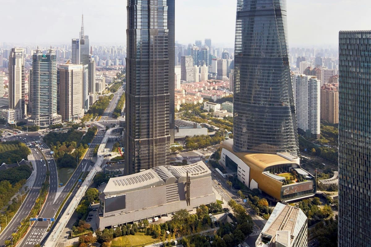 A cityscape with two prominent skyscrapers, one with a unique angular top and the other with a twisted design.