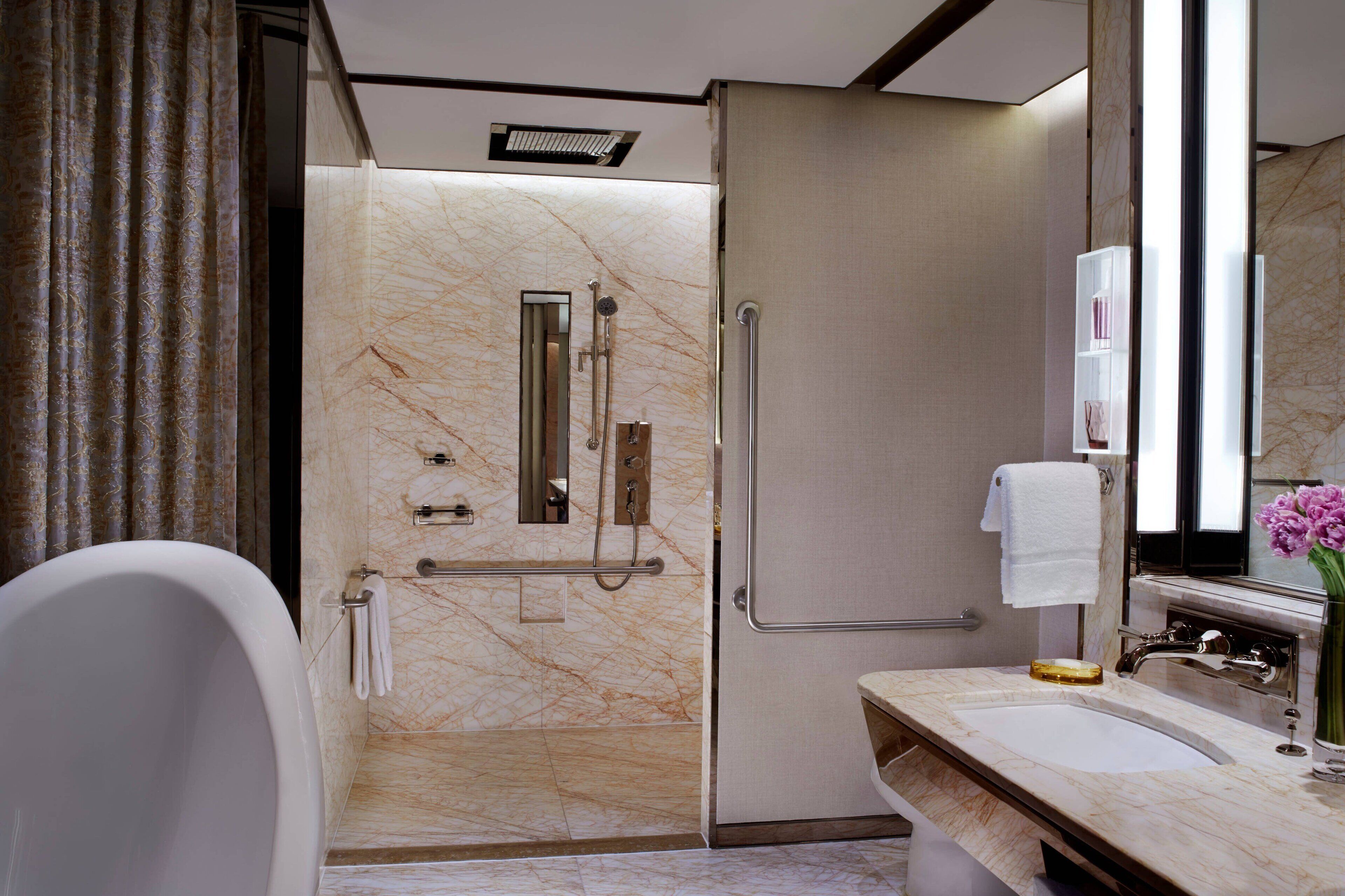 A modern bathroom with a bathtub, a walk-in shower, and a vanity with a mirror.