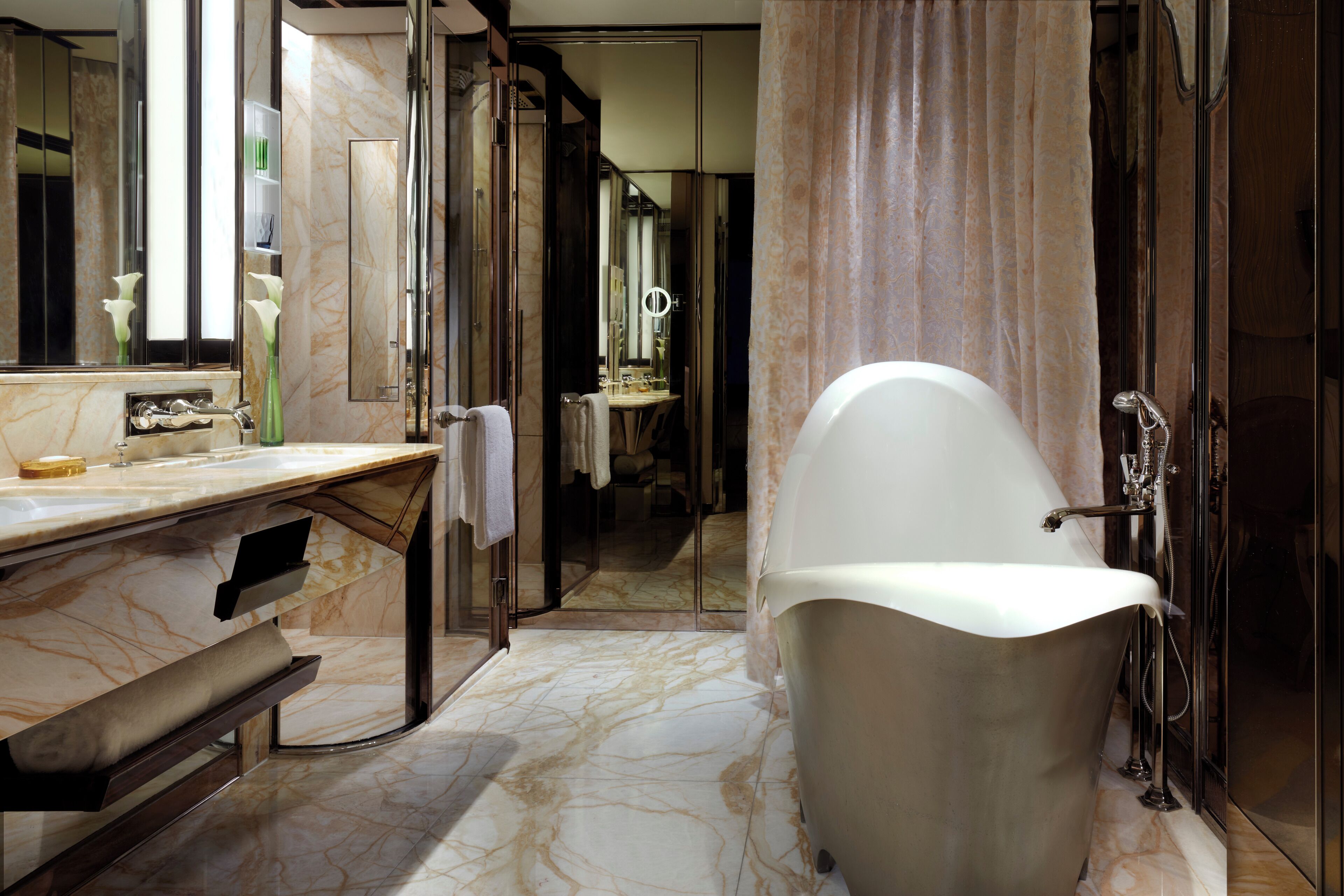 A bathroom with a freestanding bathtub, a marble countertop, and a large mirror.