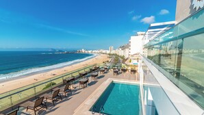 Ein Pool auf dem Dach mit Blick auf den Strand und den Ozean.