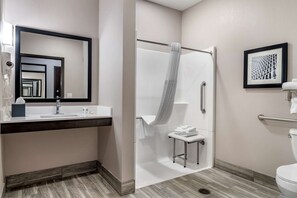 A modern bathroom with a shower, a sink with a towel rack, and a toilet.