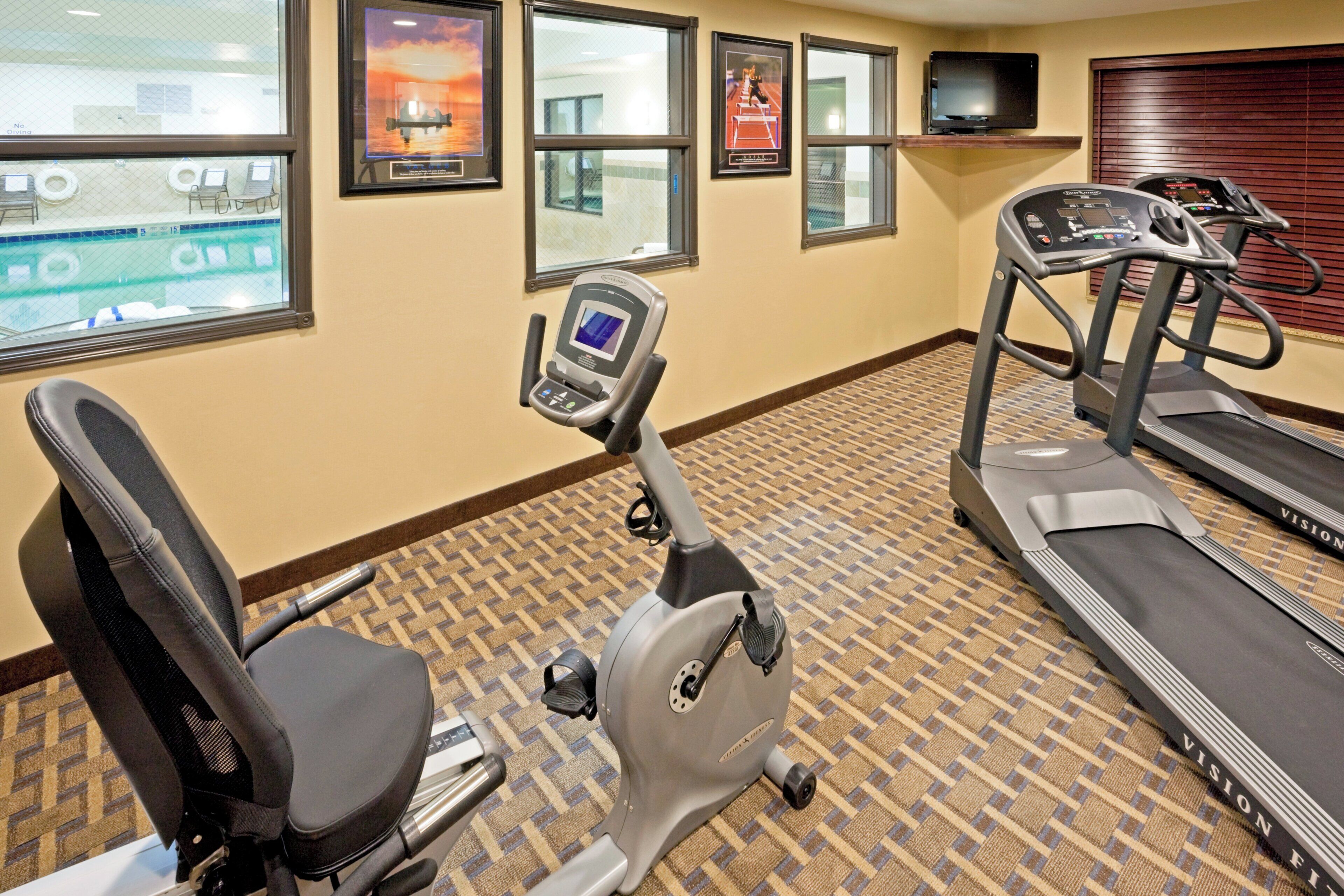 A fitness room with treadmills, an elliptical, and a stationary bike.