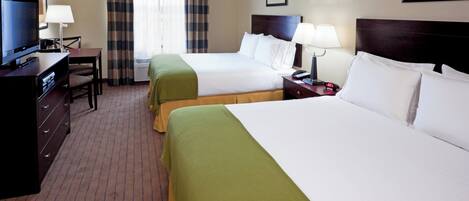 Une chambre d’hôtel avec deux lits, un bureau, une télévision et une fenêtre avec des rideaux.