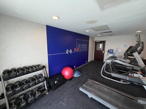 A gym with exercise equipment, a wall with motivational text, and a door. - Holiday Inn Express Hotel & Suites Syracuse North - Cicero by IHG (Cicero)