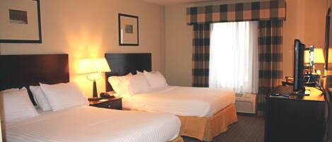 A hotel room with two beds, a desk with a computer, and a television.