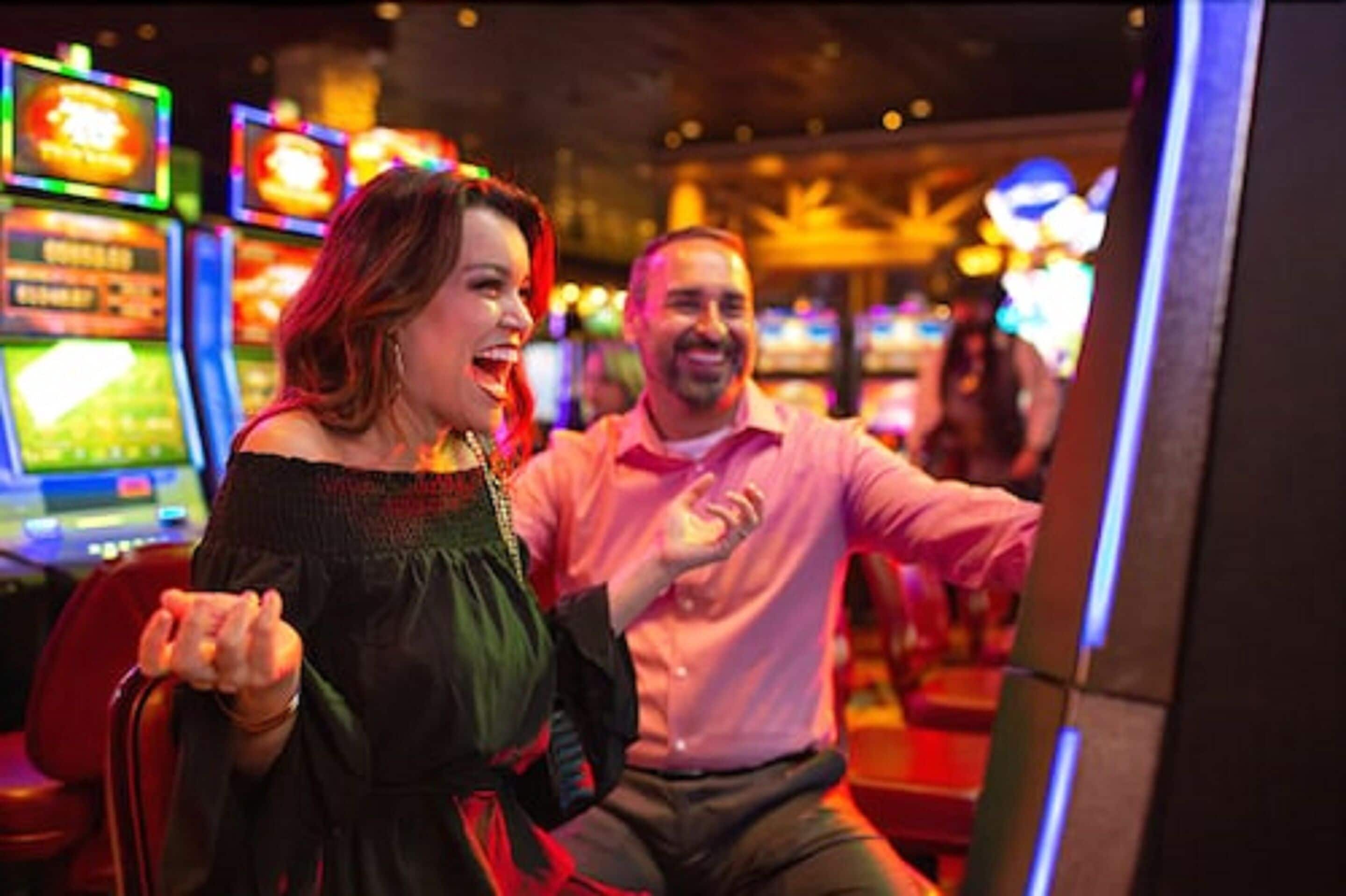 Un couple dans un casino, avec des machines à sous en arrière-plan.