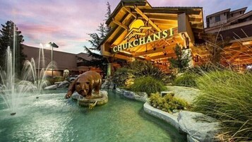 Um edifício com uma placa que diz "CHUKCHANSTI" e uma estátua de urso em frente.
