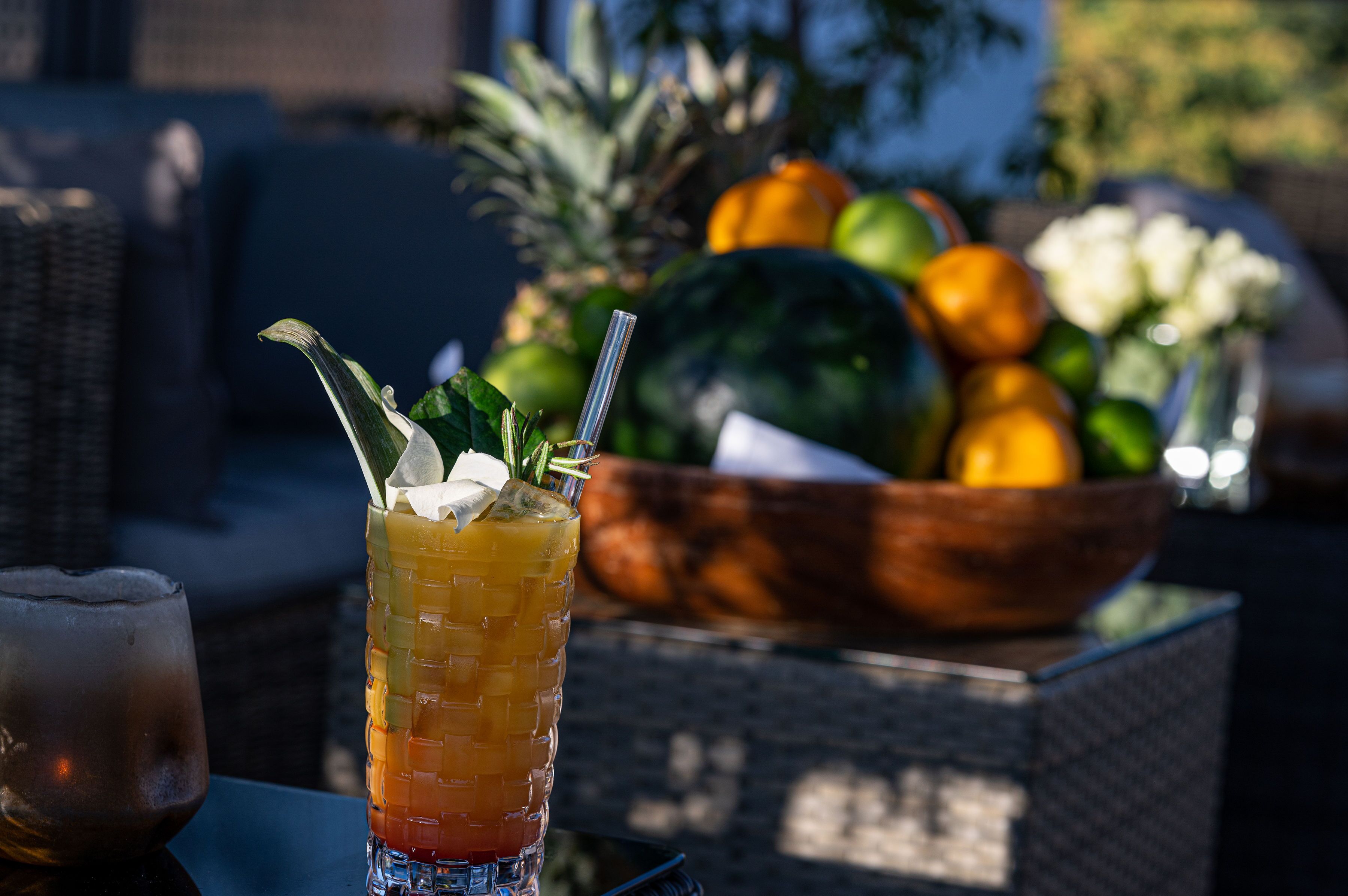 A table with a drink and a bowl of fruit.