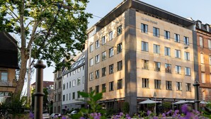 A multi-story hotel with a modern facade, large windows, and a restaurant on the ground floor. - Qube Hotel Bergheim (Heidelberg)