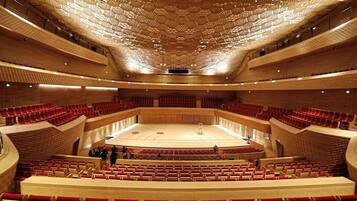 A large, modern auditorium with tiered seating and a geometric ceiling design.