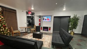 Ein modernes Wohnzimmer mit Kamin, Weihnachtsbaum und einem an der Wand befestigten Flachbildfernseher.