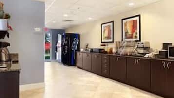 Welcome to our lobby, featuring a long reception counter, digital screen, coffee machine, and refrigerator.
