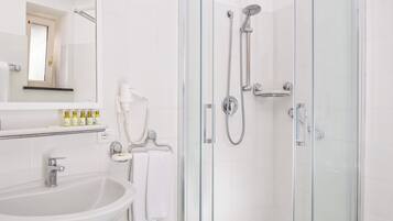 Ein Badezimmer mit Duschkabine, Waschbecken und Toilette.