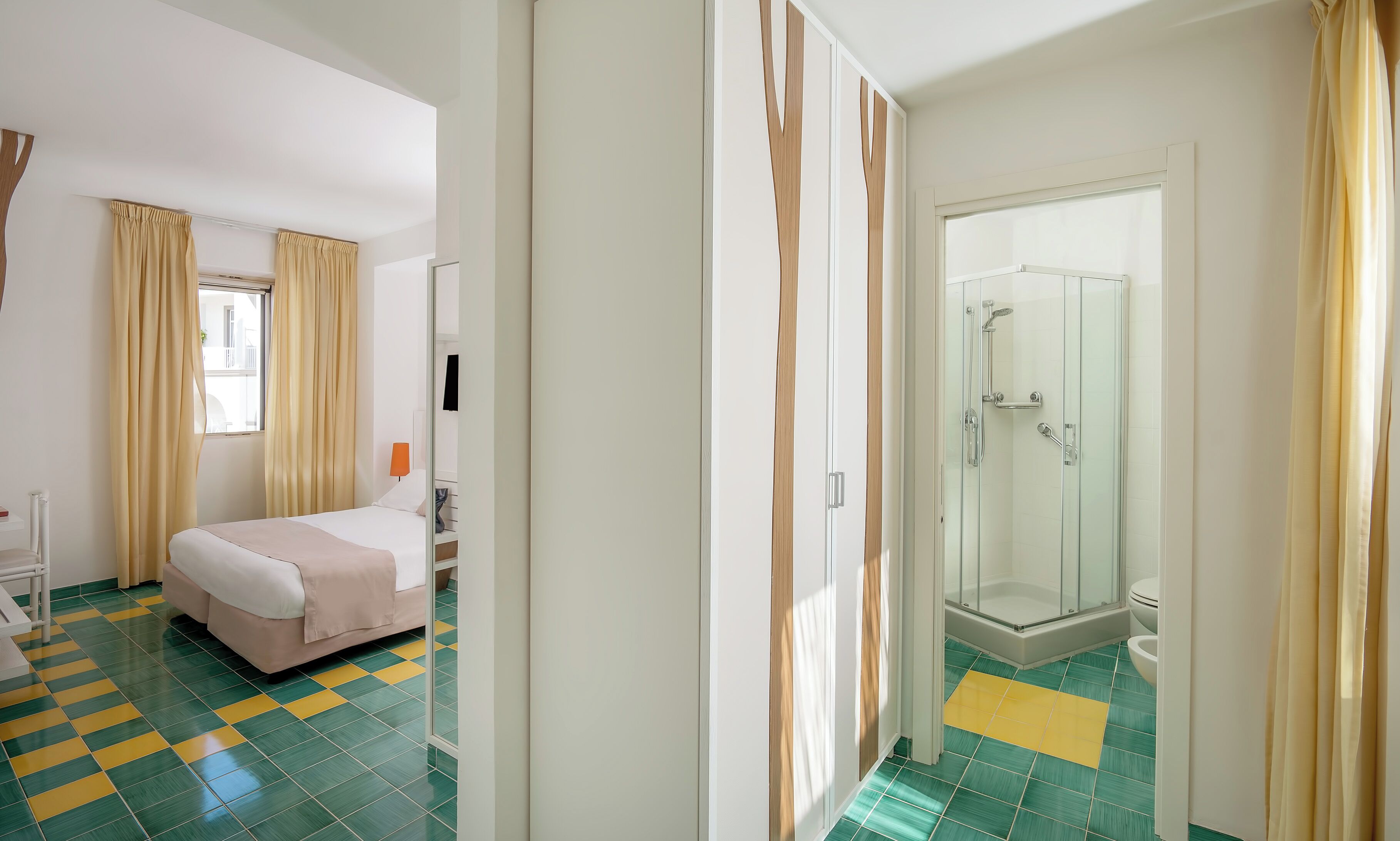 Ein Hotelzimmer mit Bett, Dusche und einem Vorhangfenster.
