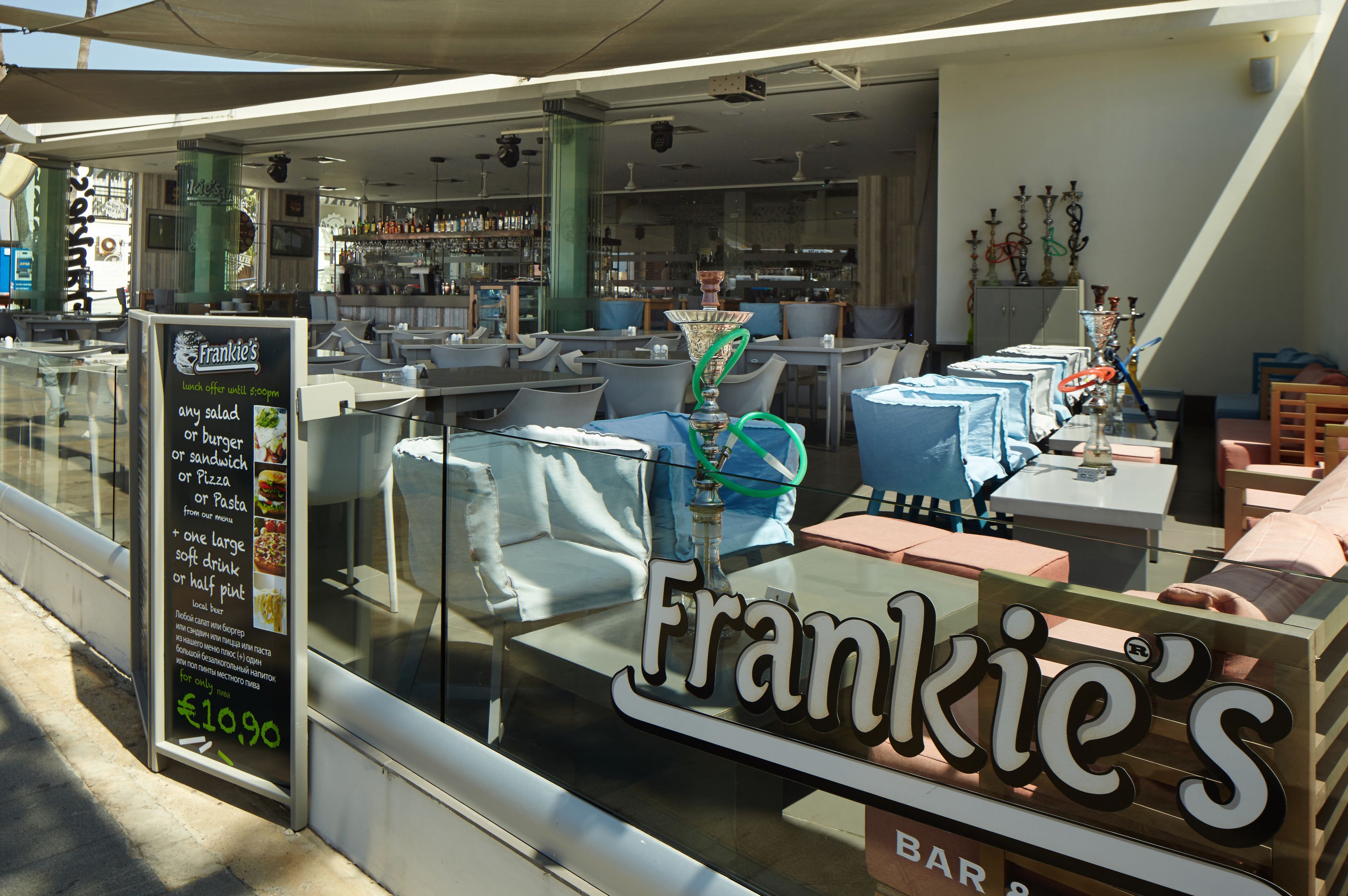 A restaurant interior with a bar area, tables, and chairs.