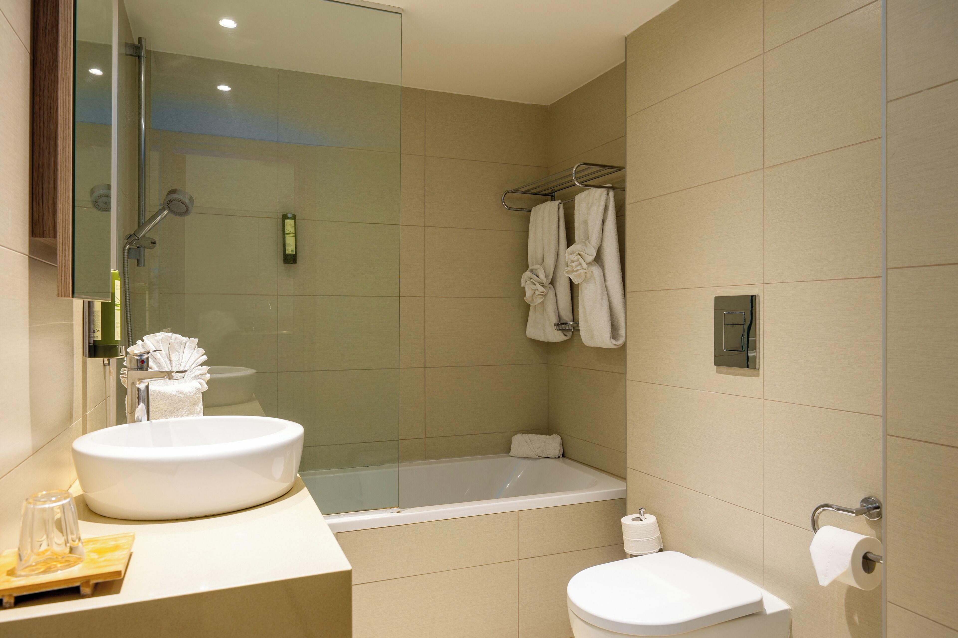 Ein modernes Badezimmer mit einem großen Waschbecken, einer Toilette und einer Badewanne.