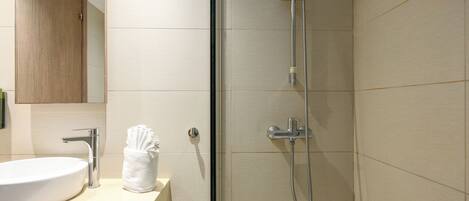 A bathroom with a sink, mirror, and shower.