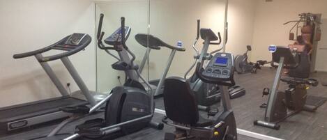 A gym with various exercise machines including treadmills, elliptical trainers, and stationary bikes.