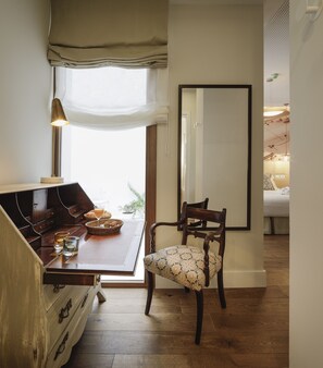 A cozy room with a wooden dining table, a chair, and a large mirror on the wall.
