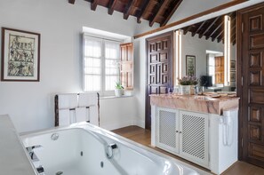 A bathroom with a bathtub, a shower, a sink, and a mirror.