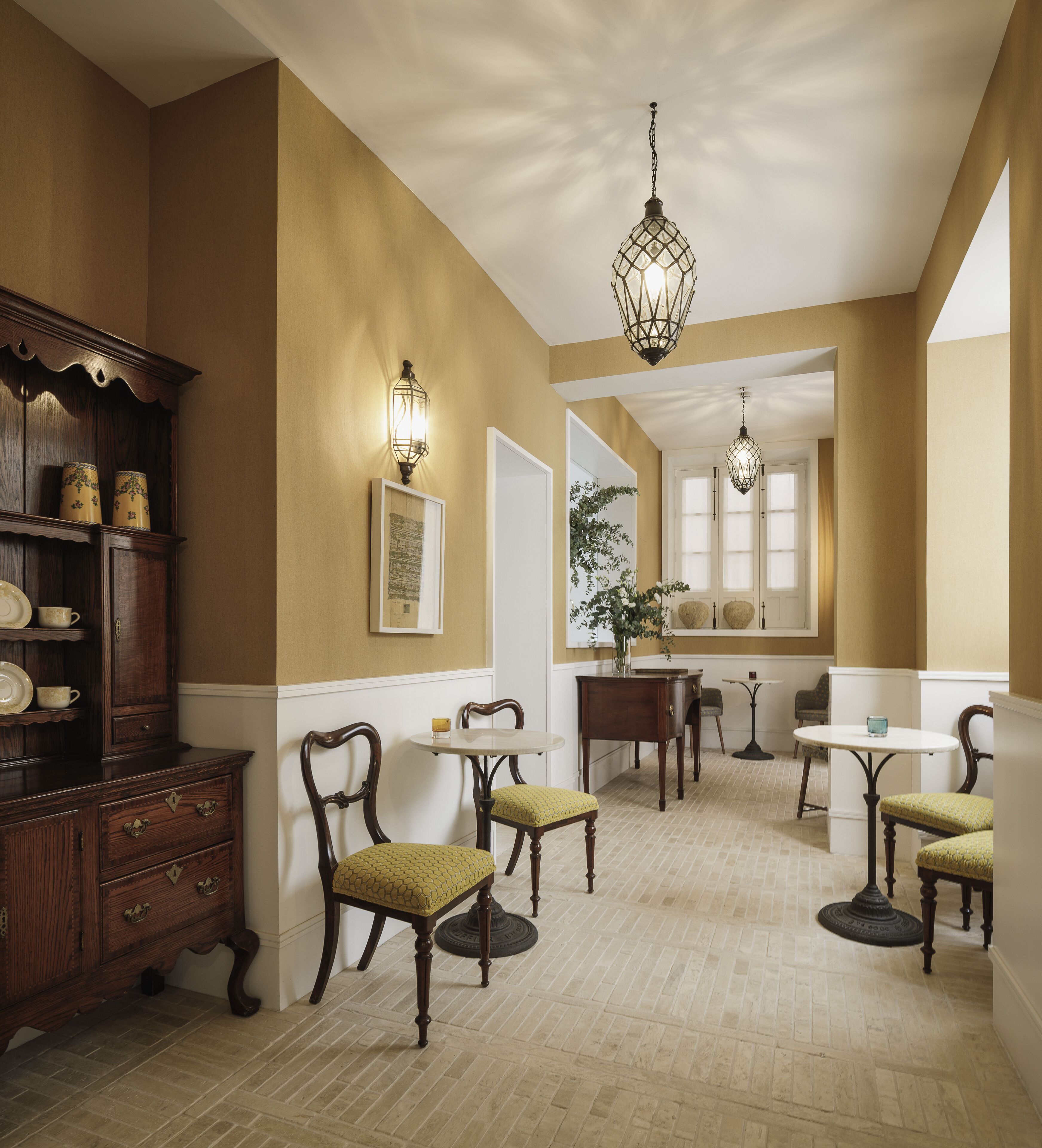 A dining area with wooden furniture, pendant lighting, and a view of the dining room.
