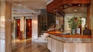 A hotel lobby with a reception desk, a staircase, and a statue. - Hotel Piedra (Carreno)