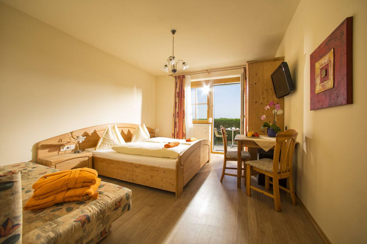 Une chambre à coucher avec un lit, une chaise, un bureau et un téléviseur.