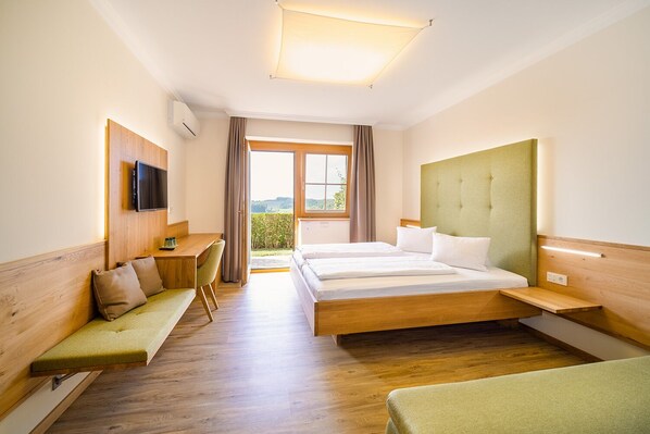 Une chambre d’hôtel avec un lit, un bureau, une chaise et un téléviseur.