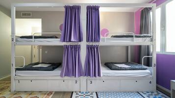 A bunk bed room with four beds, numbered 1 to 4, and purple curtains.