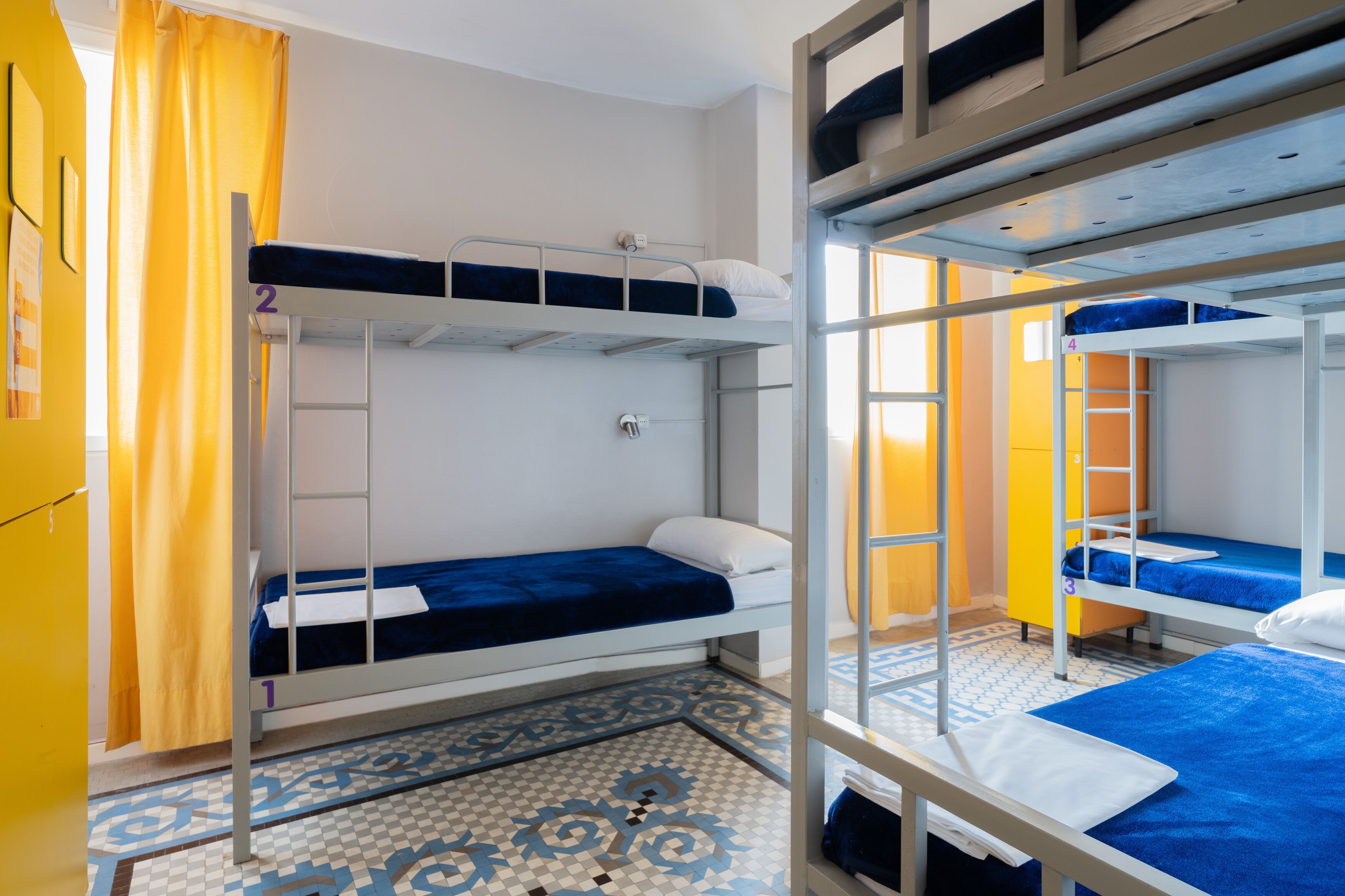 A bunk bed room with a patterned floor, a yellow curtain, and a visible bunk number 2.