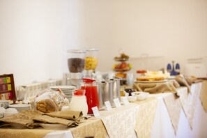 A buffet table with various food items and beverages.