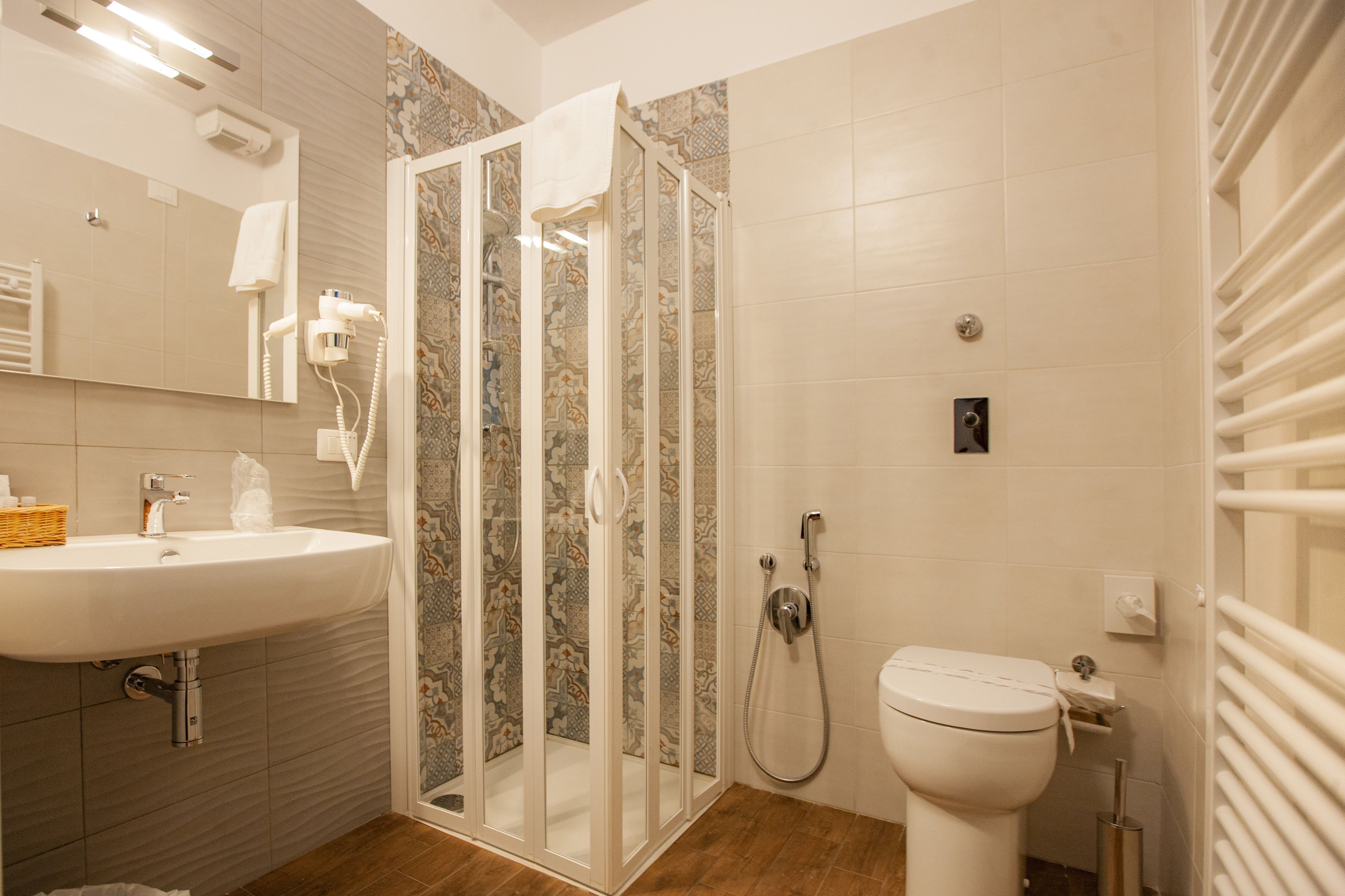 Une salle de bain moderne avec une douche à parois de verre, un lavabo blanc et des toilettes.