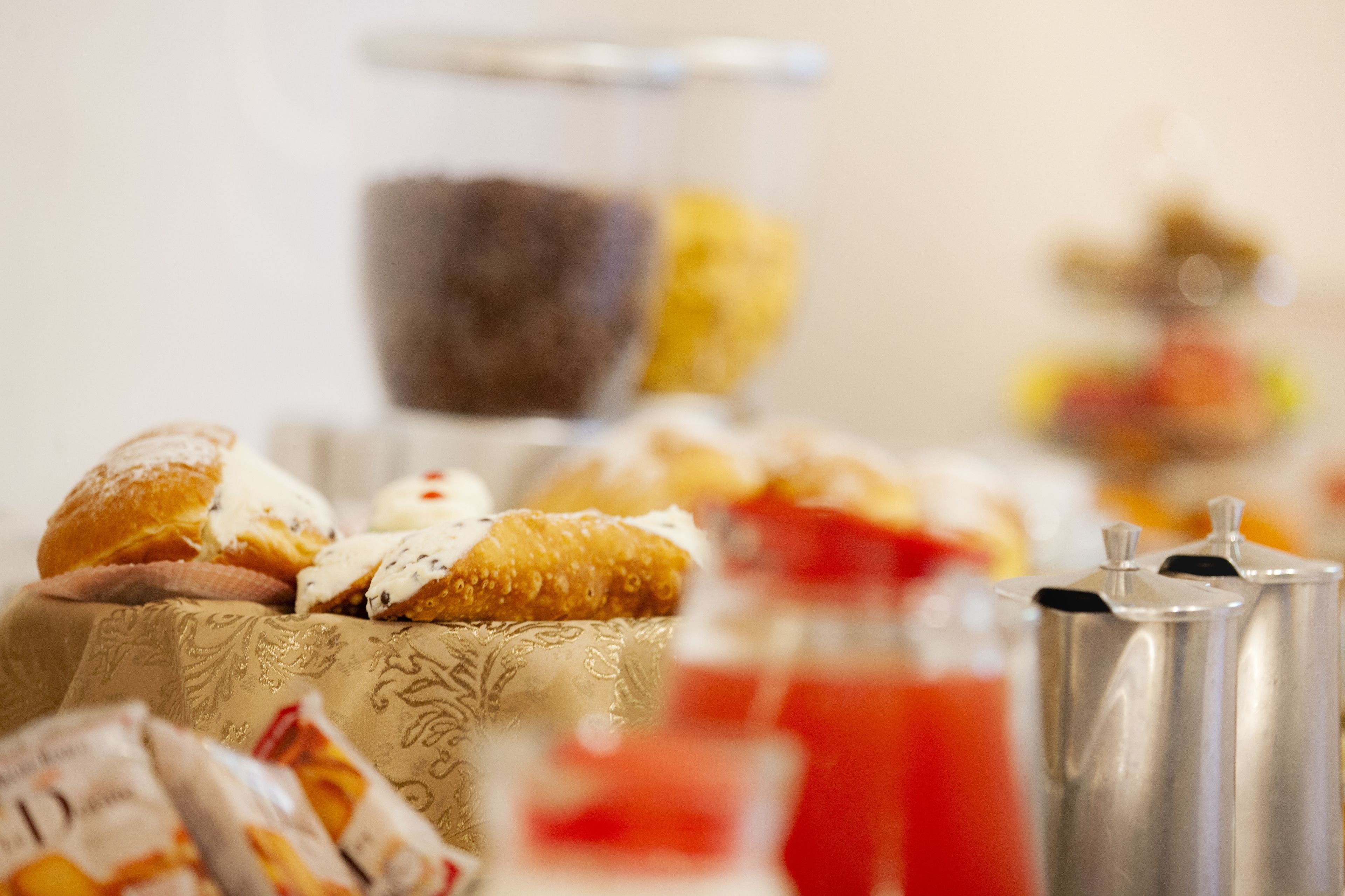 Ein Frühstücksbuffet mit Gebäck, einer Kaffeekanne und Marmelade.