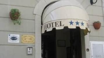 A hotel entrance with a sign that reads "HOTEL" and a smaller sign below it.