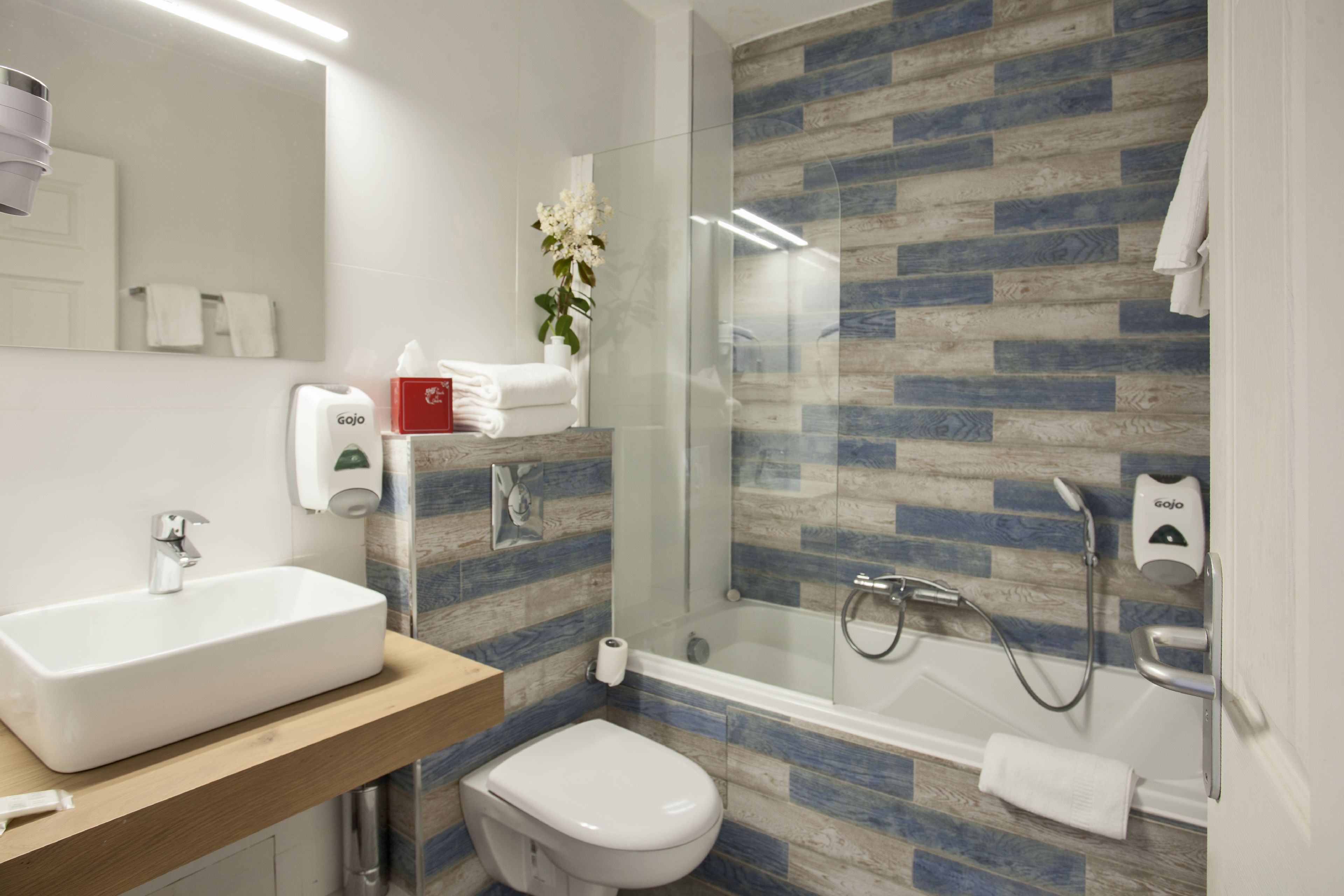 Un baño moderno con lavamanos, inodoro y ducha con cerramiento de vidrio.