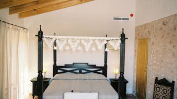 Ein Himmelbett mit Spitzenvorhang, Holzboden, Wand mit Muster und Holztür.