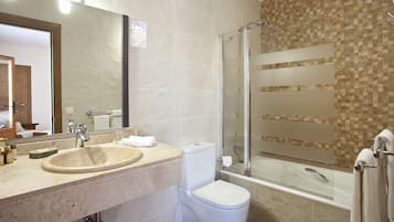 Un baño moderno con lavabo, inodoro y ducha con mampara de vidrio.