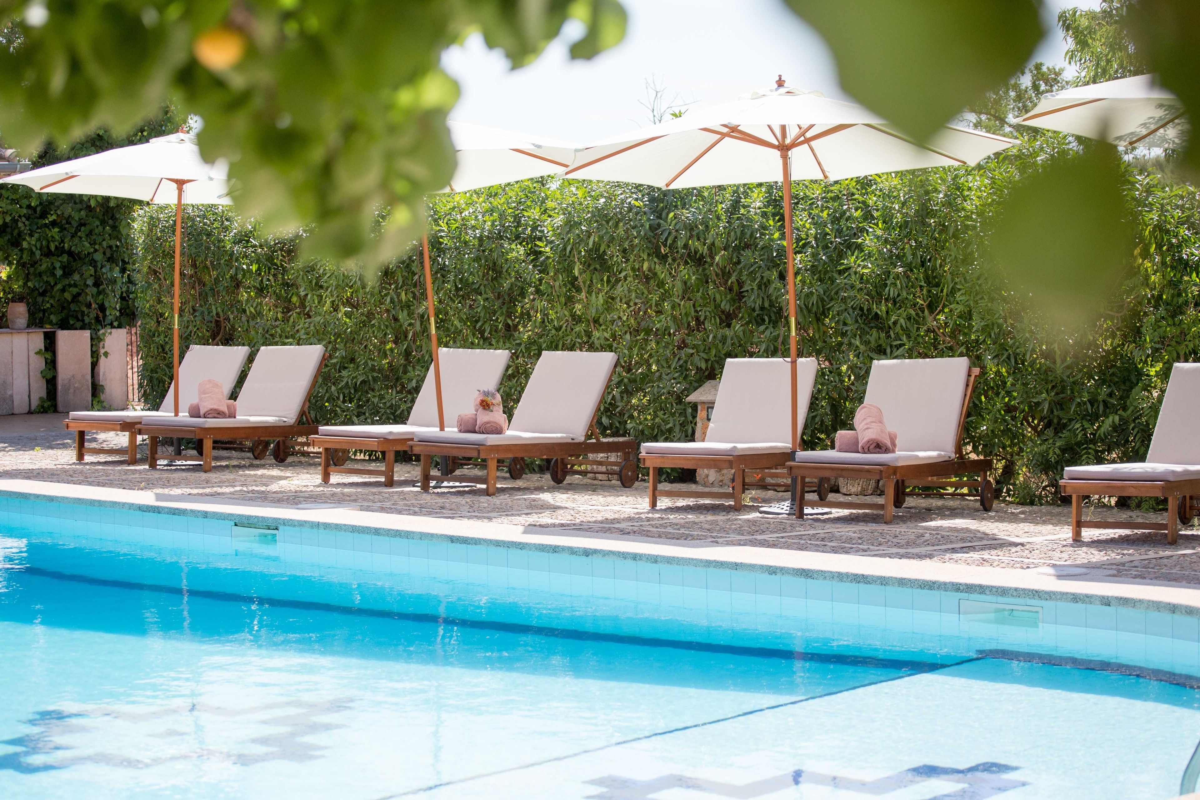 A poolside area with lounge chairs and umbrellas.