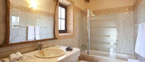 A bathroom with a marble sink, a toilet, and a glass-enclosed shower.