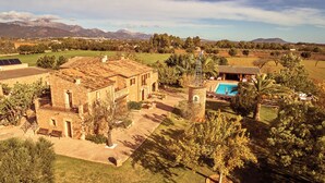 A large estate with a swimming pool, stone buildings, and expansive green fields. - Agroturismo Es Quatre Cantons (Binissalem)