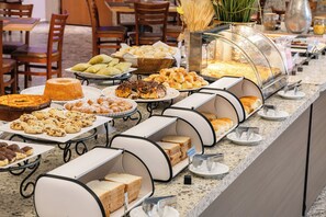 A buffet with various food items including pastries, bread, and desserts. - Dan Inn Franca by Nacional Inn (Franca)