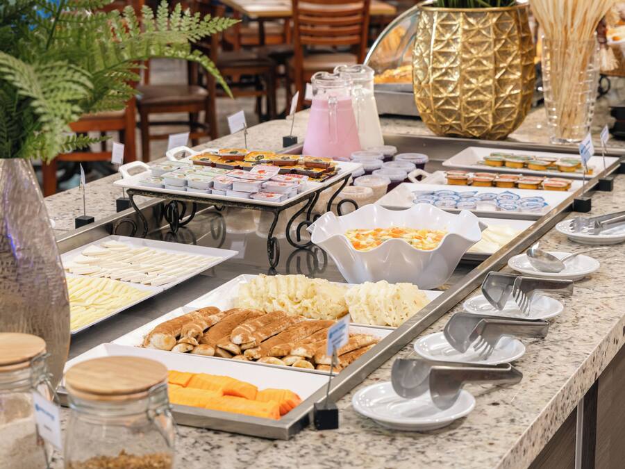 A buffet with various food items and utensils.