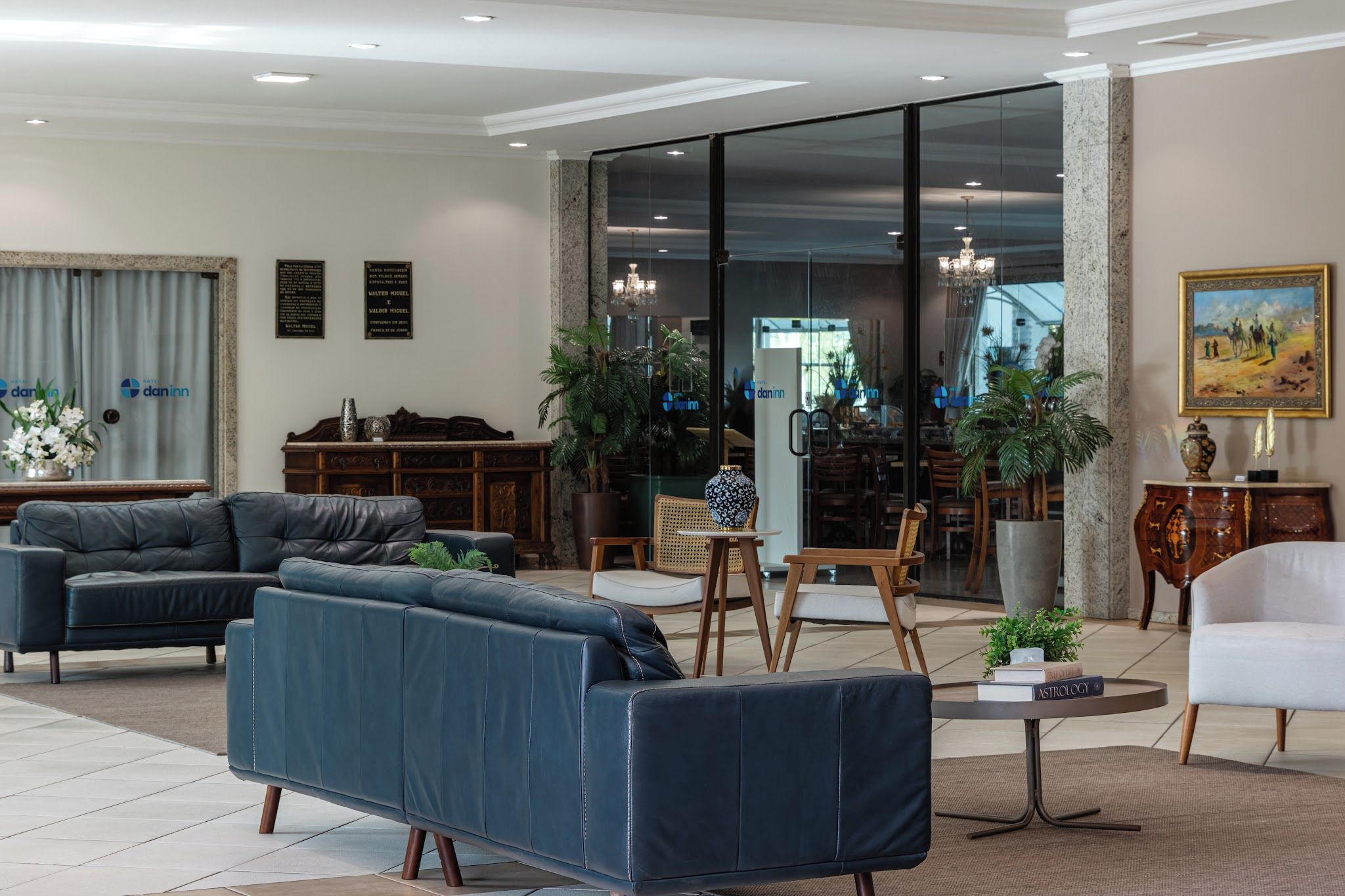 Ein modernes Wohnzimmer mit Ledersofas, einem Essbereich und einer großen Glasdoor, die auf einen Balkon führt.
