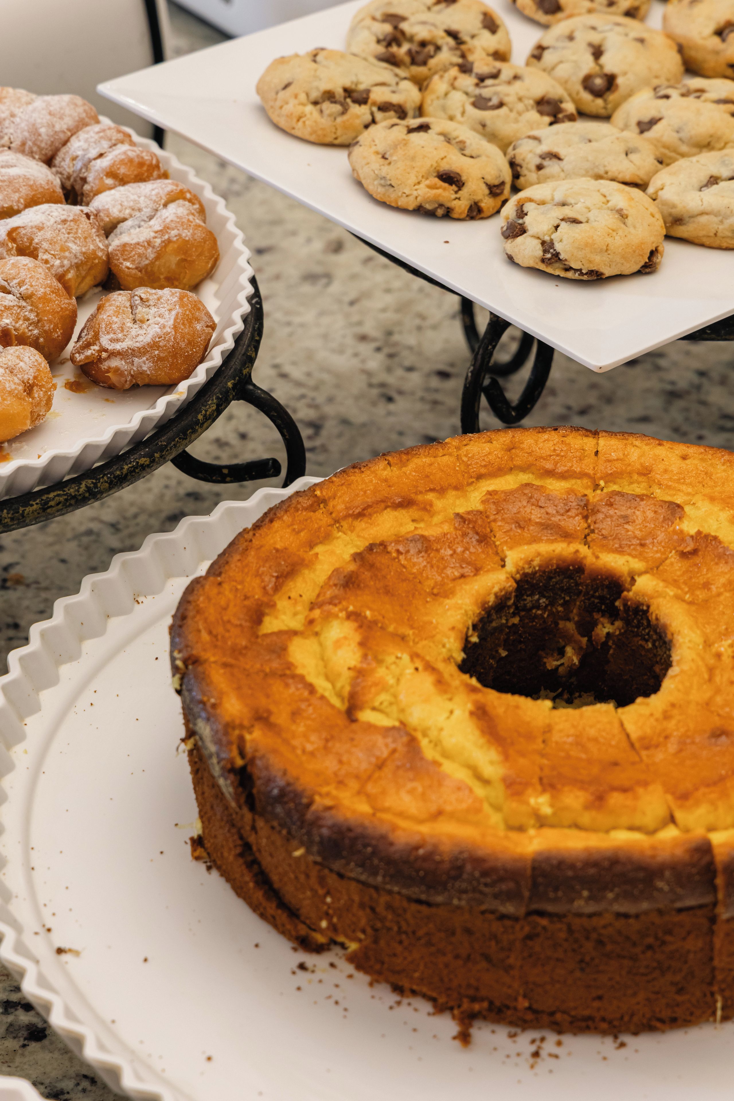 A table with various baked goods including a bundt cake, cookies, and pastries.