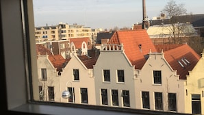 Uitzicht op gebouwen met rode pannendaken en een schoorsteen.