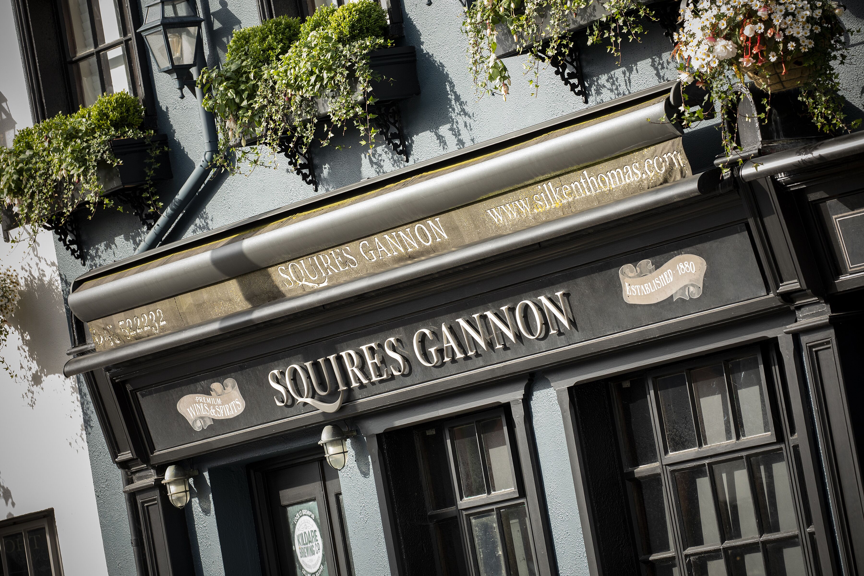 Un edificio con un letrero que dice "Squires Gannon" y una dirección de sitio web "www.silkerthomas.com".