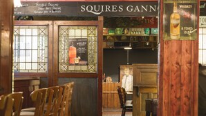 A bar with wooden furniture and a sign reading "SQUIRES GANNE". - Silken Thomas (Kildare)